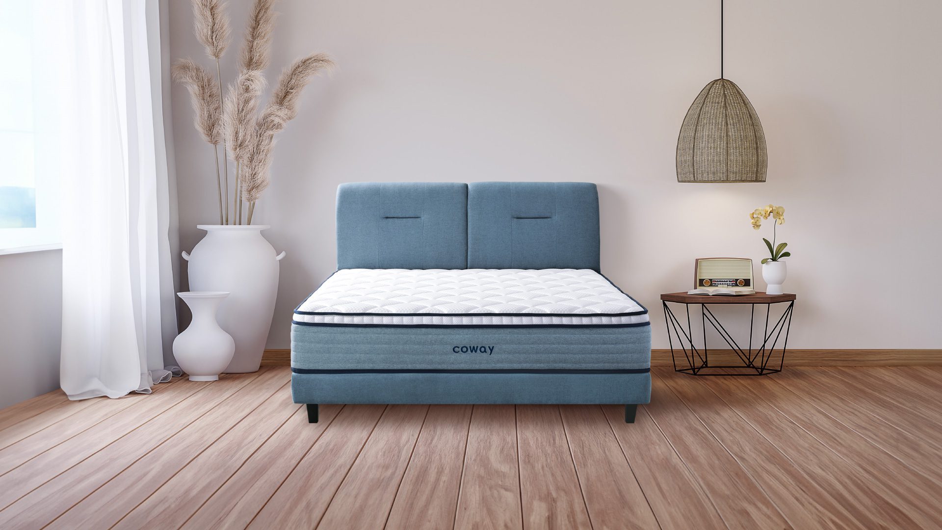 coway-prime-lite-series-mattress-at-the-center-of-the-room-with-wooden-floors-and-a-huge-decorative-plant-vase-at-the-side
